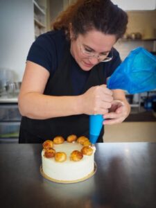 Debora icing a cake in the Cambridge bakery